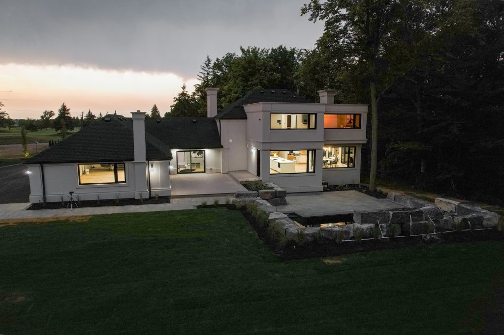 A backyard and large white modern house