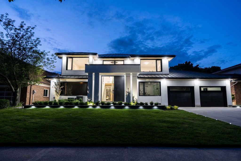 A front of a modern house lit up at night